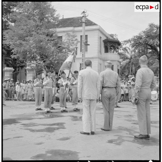 Les membres de la mission militaire américaine, M. Melby et le général Erskine, rendent les honneurs au drapeau et sa garde, au cours d'une cérémonie Haïphong.