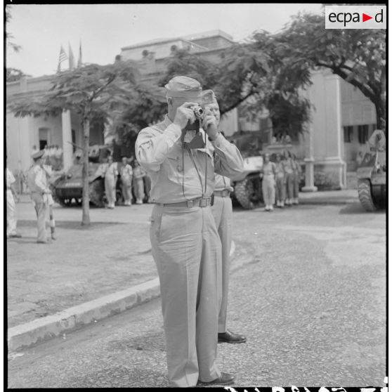 Le général Erskine, membre de la mission militaire américaine, prend une photographie au cours d'une prise d'armes à Haïphong.