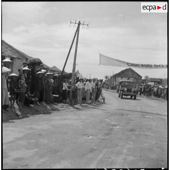 Passage dans les rues de Dap Cau du convoi transportant les membres de la mission militaire américaine Melby-Erskine.