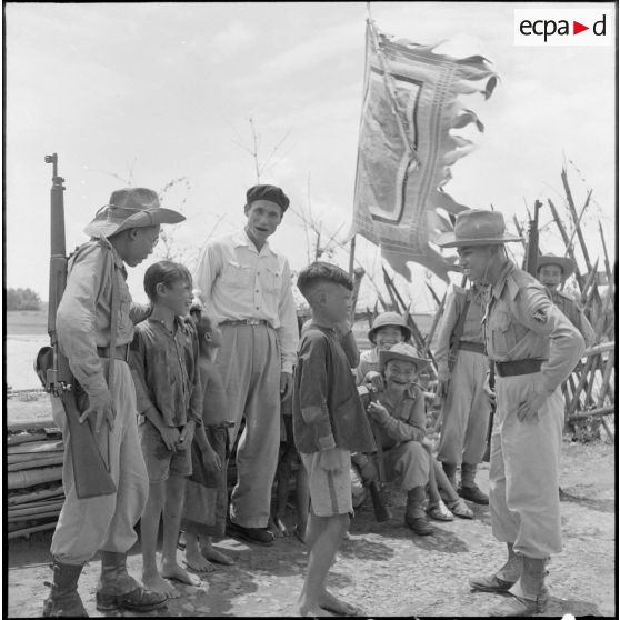 Des soldats d'une patrouille de surveillance discutent avec des enfants au poste de milice de Xuan Quang.