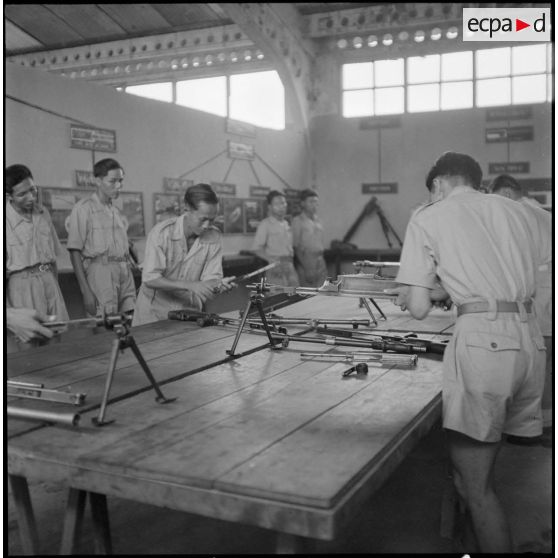 Elèves de l'école des cadres d'Hanoï lors d'une séance de montage et démontage d'un fusil-mitrailleur Bren.