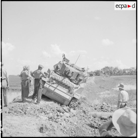 Char M5 Stuart basculé sur le côté d'une route accidentée dans le secteur de Phu Ly.