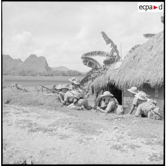 Soldats embusqués en position de tir dans un village du secteur de Phu Ly.