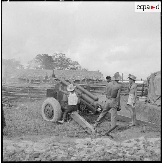 Chargement et mise en batterie par des artilleurs d'un M2A1 de 105 mm dans un poste au nord-ouest de Phu Ly.