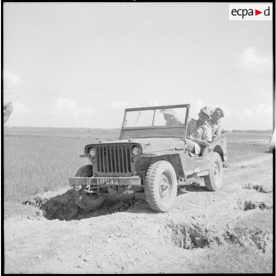 Soldats en patrouille dans une jeep sur une route comportant de nombreuses coupures, dans le secteur de Phu Ly.