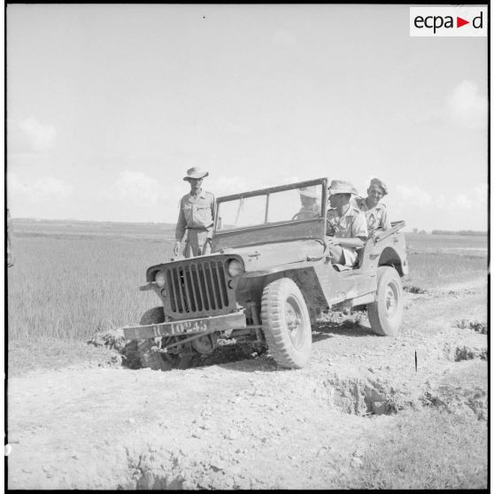 Soldats en patrouille dans une jeep sur une route comportant de nombreuses coupures, dans le secteur de Phu Ly.