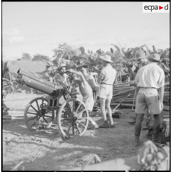 Réglage d'un canon de 75 mm par des artilleurs du 64 RAA (régiment d'artillerie d'Afrique).