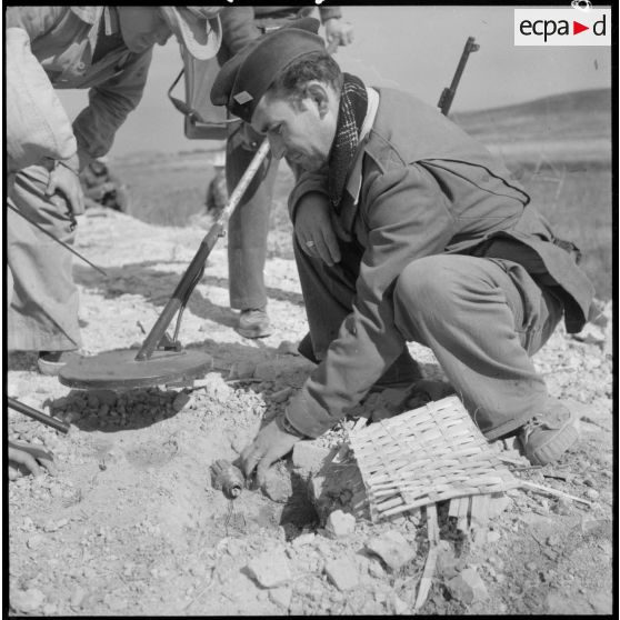 Déterrement d'une mine antipersonnel de fabrication artisanale par un sergent-chef du génie sur la route coloniale n°1 au Tonkin.