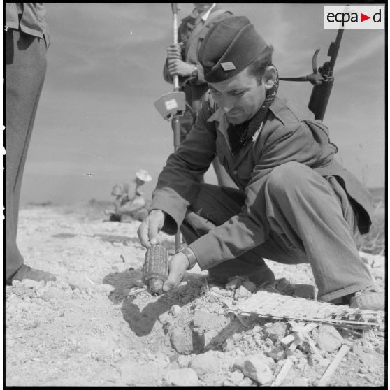 Déterrement d'une mine antipersonnel de fabrication artisanale par un sergent-chef du génie sur la route coloniale n°1 au Tonkin.