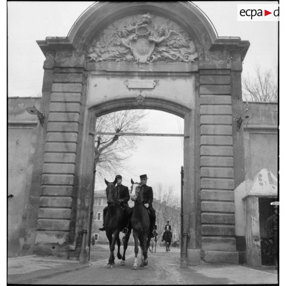 Des sous-maîtres de manège, écuyers du Cadre Noir, sortent à cheval de la caserne Miollis.