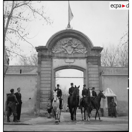 Des sous-maîtres de manège, écuyers du Cadre Noir, sortent à cheval de la caserne Miollis.