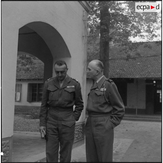 Dans la cour de l'état-major de la zone opérationnelle du Tonkin (ZOT),  le général Boyer de La Tour s'entretient avec le colonel Edon, commandant le groupe mobile nord-africain (GMNA).