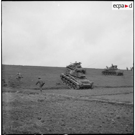 Progression de chars M24 Chaffee du 1er régiment de chasseurs à cheval à travers champs et rizières, sous la protection de fantassins.