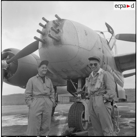 Deux navigateurs posent devant un avion bombardier Douglas A-26B avant le départ, sur la base aérienne de Cat Bi.