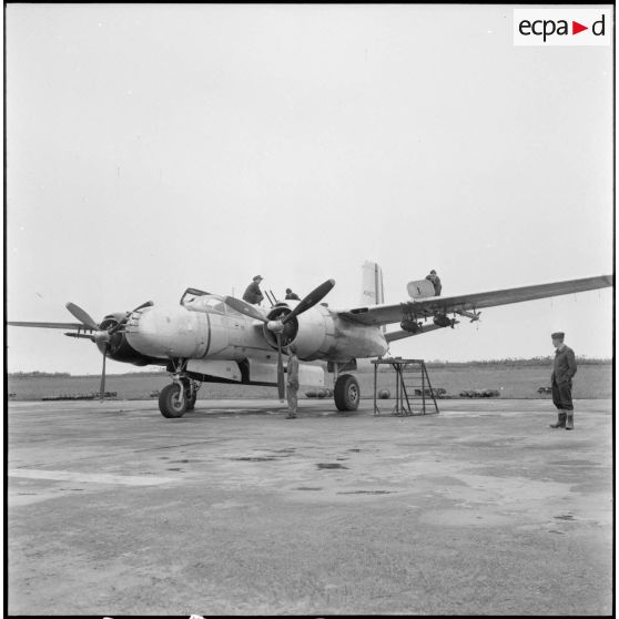 Avion A-26B avec ses mécaniciens sur le terrain d'aviation de Cat Bi.