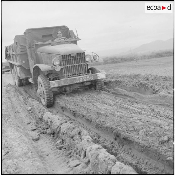 Camion GMC 6X6 sur un chemin boueux.