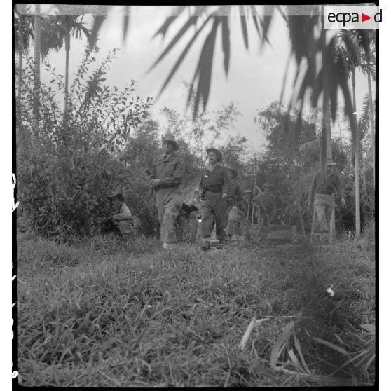 Des légionnaires du 5e REI pénètrent dans un village au cours d'une opération sur la route entre Hanoï et Haïphong.