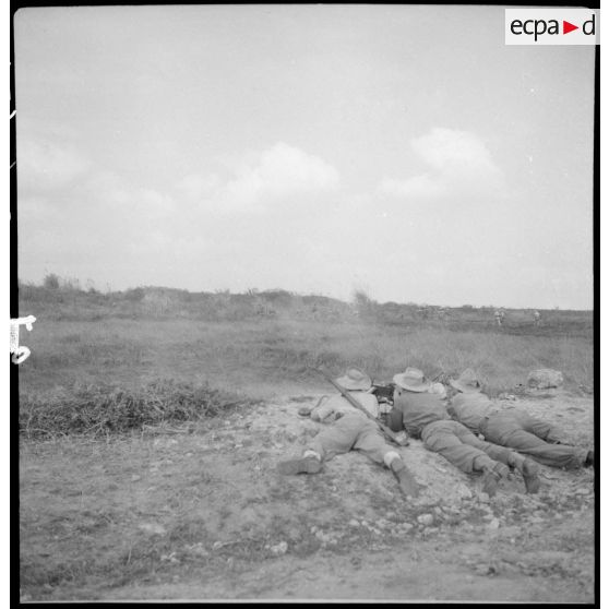 Des légionnaires du 5e REI (régiment étranger d'infanterie) embusqués en position de tir, armés d'une mitrailleuse, au cours d'une opération sur la route entre Hanoï et Haïphong.