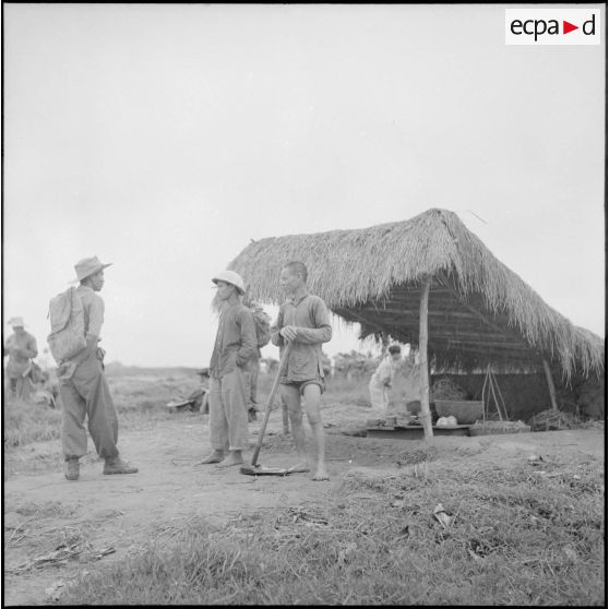 Un parachutiste indochinois discute avec des villageois au cours de l'opération Méduse.