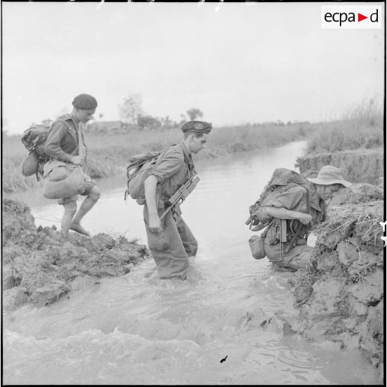 Les troupes franco-vietnamiennes franchissent un arroyo lors de leur progression vers le village d'An Binh au cours de l'opération Méduse.