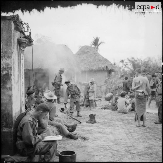 Les troupes ayant passé la nuit dans le village d'An Lao préparent le café tandis que le commandant Fourcade transmet par radio les différentes instructions pour la marche à suivre dans la journée.