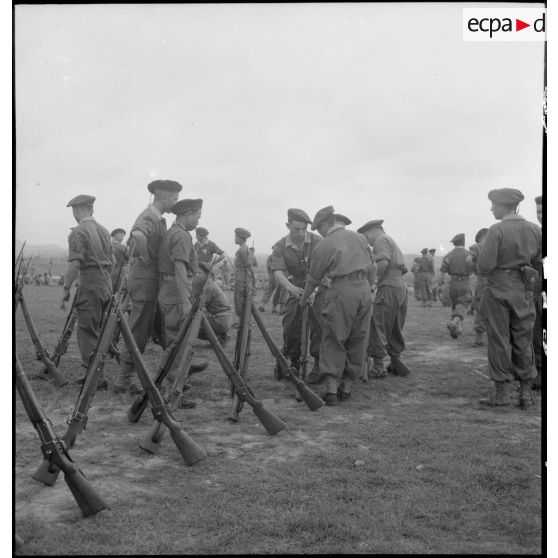 Des soldats installent leurs fusils en faisceaux à l'occasion d'une cérémonie à Vinh Yen.