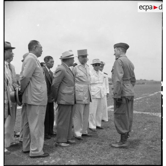 Le général de Lattre de Tassigny, commandant en chef en Indochine et Tran Van Huu, président du conseil des ministre de l'Etat du Vietnam, accompagné de personnalités sur le terrain d'aviation de Vinh Yen.