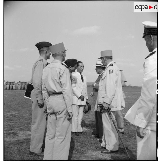 Le général de Lattre de Tassigny, commandant en chef en Indochine et Tran Van Huu, président du conseil des ministre de l'Etat du Vietnam, saluent des personnalités sur le terrain d'aviation de Vinh Yen.