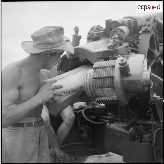 Mise en place d'un obus et de sa charge dans la culasse d'un canon de 155 médium.