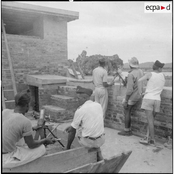 A l'intérieur de fortifications, les tirailleurs sénégalais armés de mortiers surveillent les environs du rocher de Ninh Binh que l'on distingue en arrière plan.