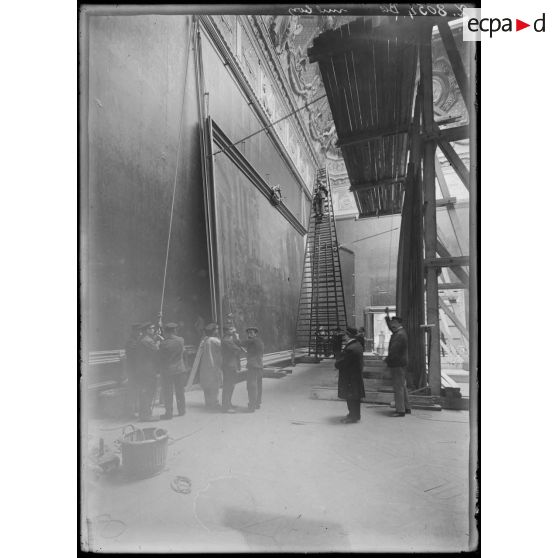 Paris. Mise en place d'un tableau au Louvre. [légende d'origine]