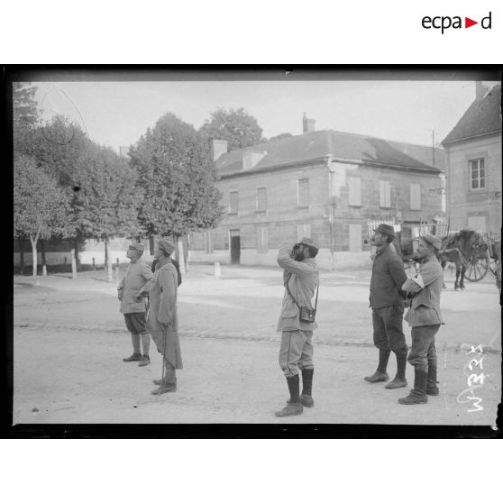 Des soldats suivent des yeux un combat aérien. [légende d'origine]