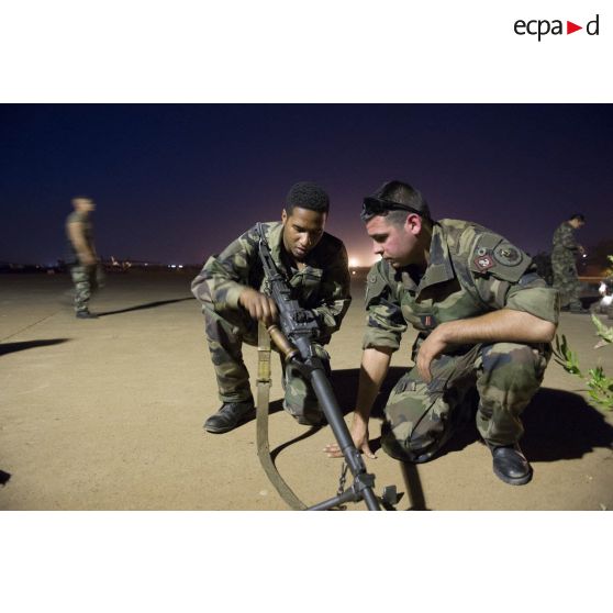 Des marsouins du 2e régiment d'infanterie de marine (2e RIMa) contrôlent le chargement d'une mitrailleuse ANF1 sur l'aéroport de Bamako, au Mali.