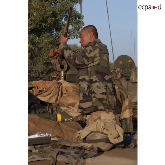 Un légionnaire du 1er régiment étranger de cavalerie (1er REC) nettoie la mitrailleuse ANF1 de son engin blindé à roues, canon de 90 mm (ERC-90) Sagaie à son arrivée à Markala, au Mali.