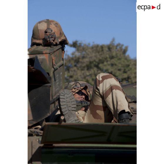 Après avoir conduit toute la nuit, un pilote du 21e régiment d'infanterie de marine (21e RIMa) se repose sur le toit de son véhicule de l'avant blindé (VAB) à Markala, au Mali.