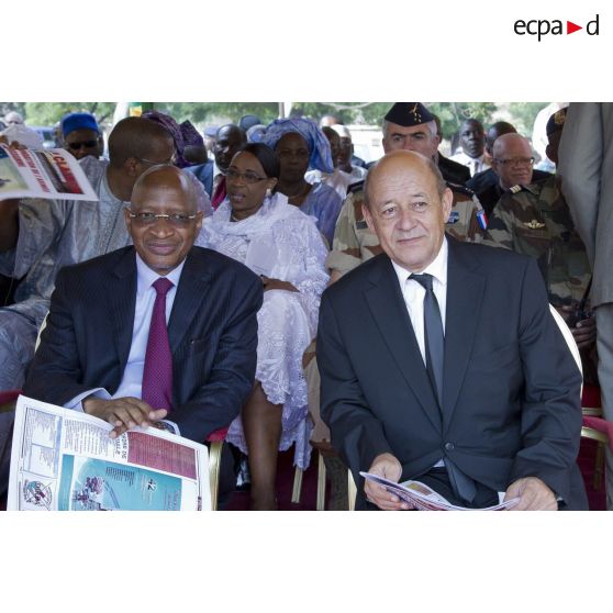 Le ministre de la Défense Jean-Yves Le Drian lit le journal Le Clairon aux côtés du ministre malien Soumeylou Boubeye Maïga lors d'une cérémonie au camp du 34e bataillon du Génie militaire à Bamako