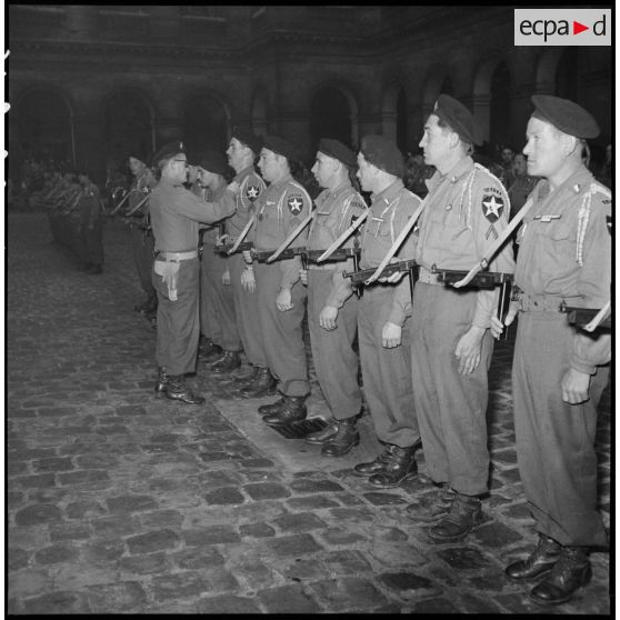 Les volontaires du 1er Bataillon français des Nations Unies (Bataillon de Corée) sont décorés lors d'une prise d'armes dans la cour d'honneur de l'Hôtel national des Invalides.