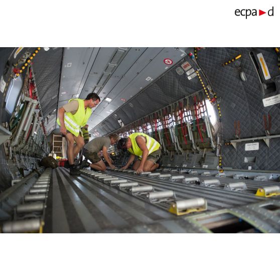 Des techniciens logistiques préparent la soute d'un avion Casa Cn-235 pour un chargement de fret sur la base aérienne (BA) 367 Capitaine François Massé à Cayenne, en Guyane française.