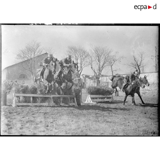 Des sous-officiers du 7e régiment de chasseurs à cheval (RCC) et leurs montures franchissent des haies improvisées.