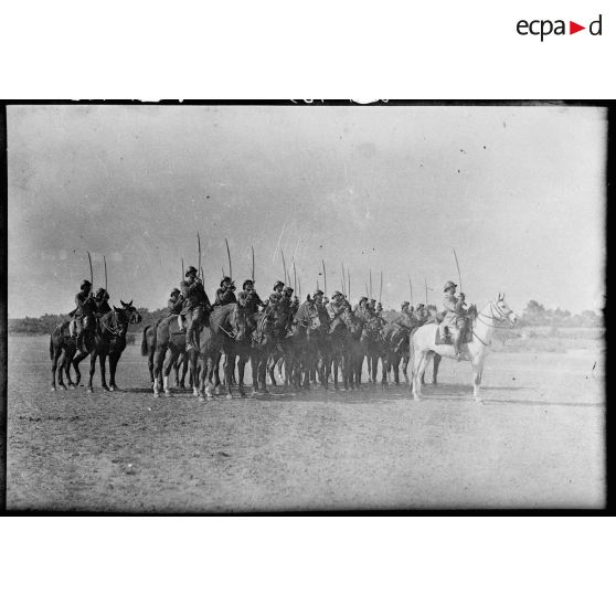 Un peloton à cheval du 7e régiment de chasseurs à cheval (RCC) fait un exercice de présenter de sabres.