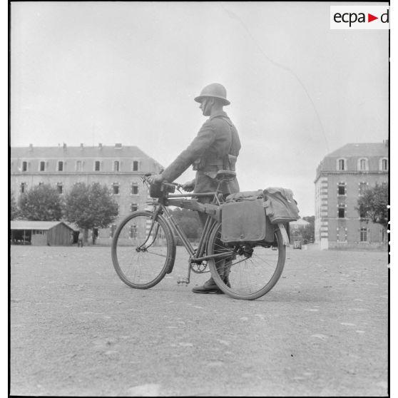 Présentation d'un vélo transportant armement et équipement individuel.