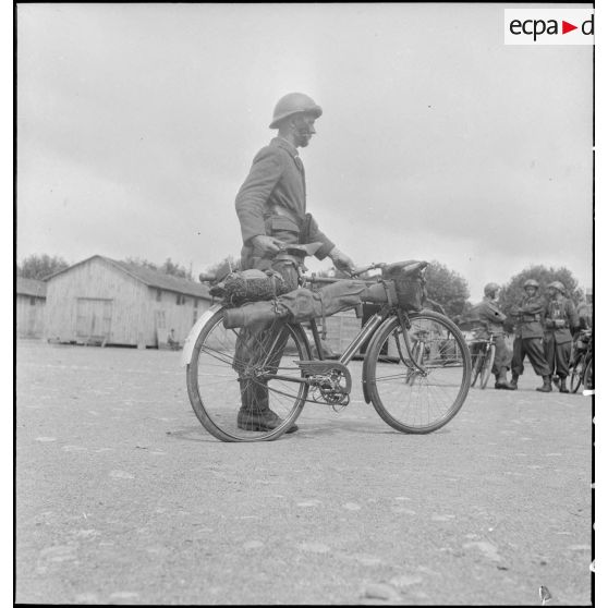 Présentation d'un vélo transportant armement et équipement individuel.