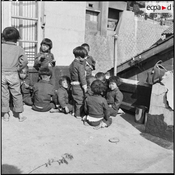 Enfants sud-coréens mangeant des biscuits dans une cour en Corée.