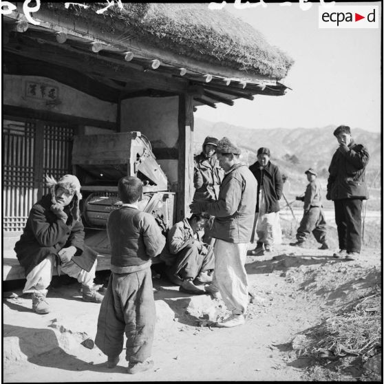 Groupe de Coréens devant une habitation dans un village.