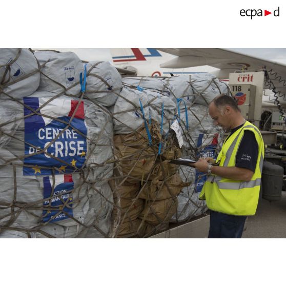 Un agent des services aéroportuaires encadre le chargement de fret à bord d'un avion sur l'aéroport de Roissy-Charles-de-Gaulle.