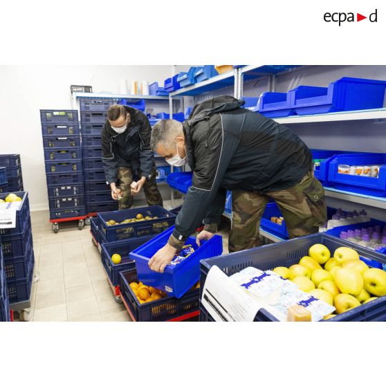 Des soldats apportent leur aide pour la manutention de produits alimentaires à l'hôpital Sainte-Anne.