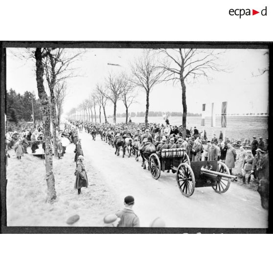 Sur une route, les troupes polonaises (75 mm M1897 hippomobile) défilent devant les officiels civils et militaires, polonais et français.