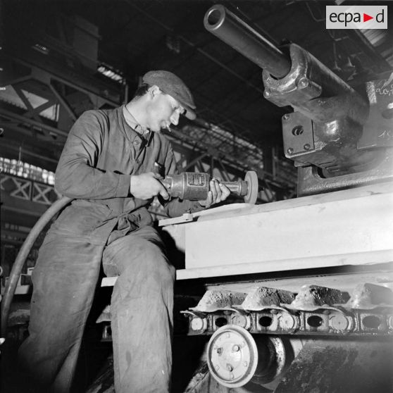 A l'atelier d'Issy-les-Moulineaux un ouvrier ponce la caisse d'un char Renault R40.