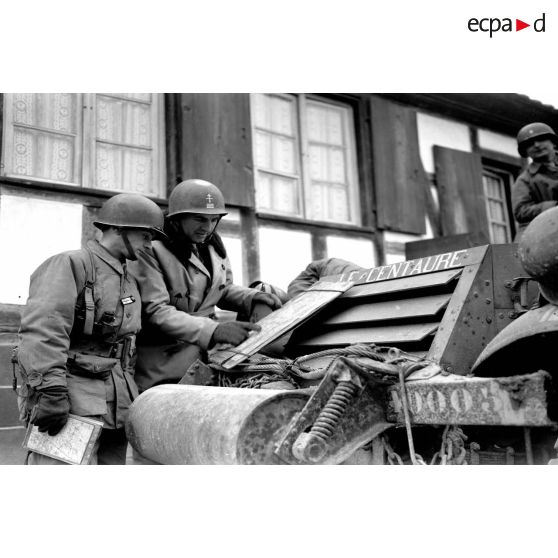 Le capitaine Robert d'Alançon, officier du renseignement, et le lieutenant Chevalier du 3e escadron du 12e régiment de chasseurs d'Afrique (12e RCA) étudient une carte sur le half-track radio baptisé Le Centaure.