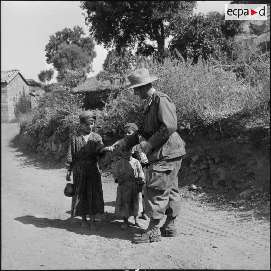 Distribution de bonbon aux enfants de Tala'n Taghrast par l'officier SAS (Section administrative spécialisée) de Tigzirt.